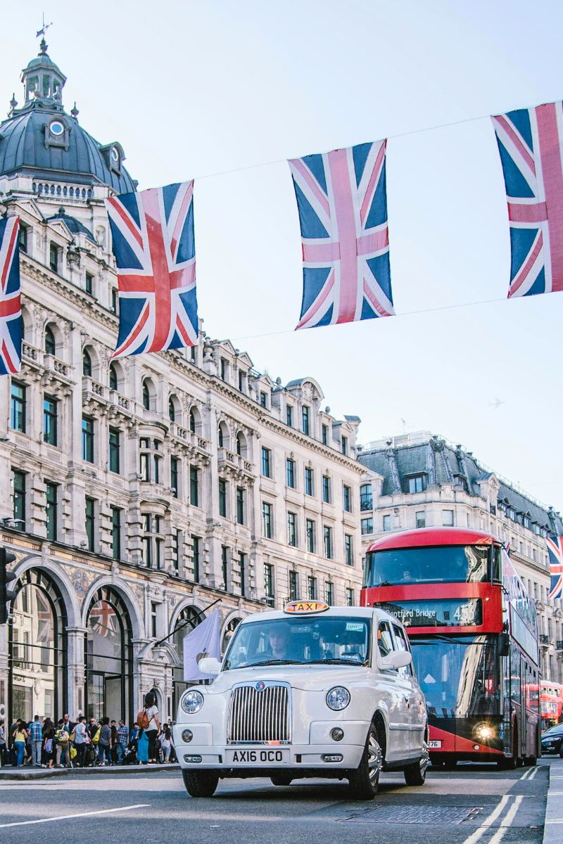 Regent Street in London with double-decker bus, taxi, and British flags overhead