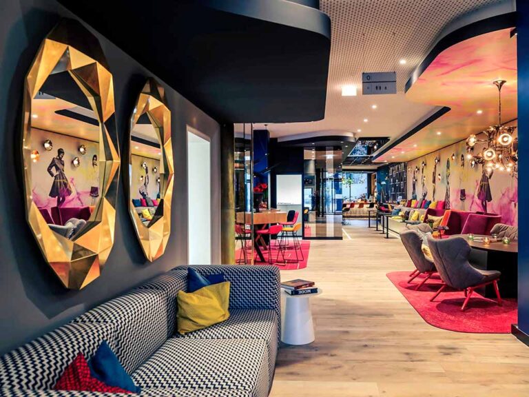 Modern lobby at Mercure Hotel Berlin Wittenbergplatz with vibrant colors and inviting seating areas