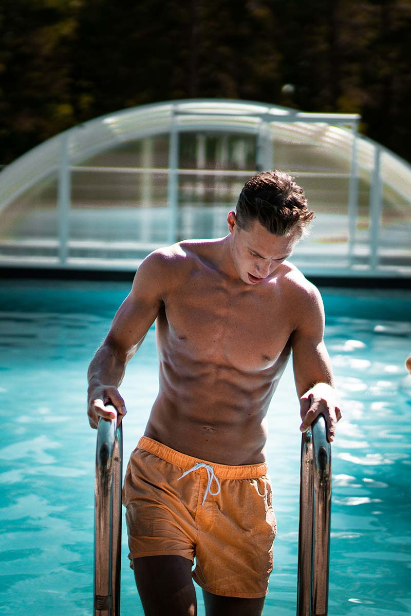 Fit man stepping out from a swimming pool