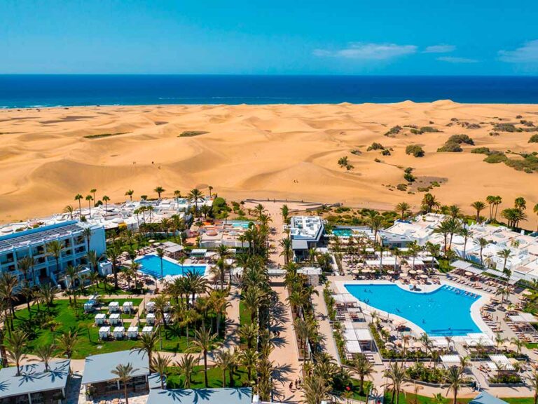 Aerial view of Riu Palace Maspalomas with the hotel in the foreground and the stunning Maspalomas dunes in the background