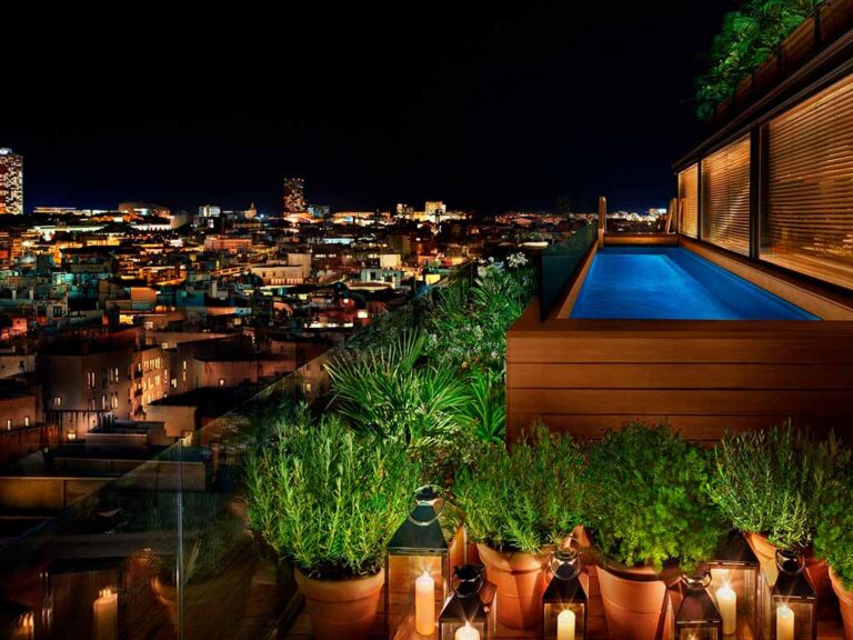 Night view of the rooftop pool at The Barcelona Edition, with stunning city views